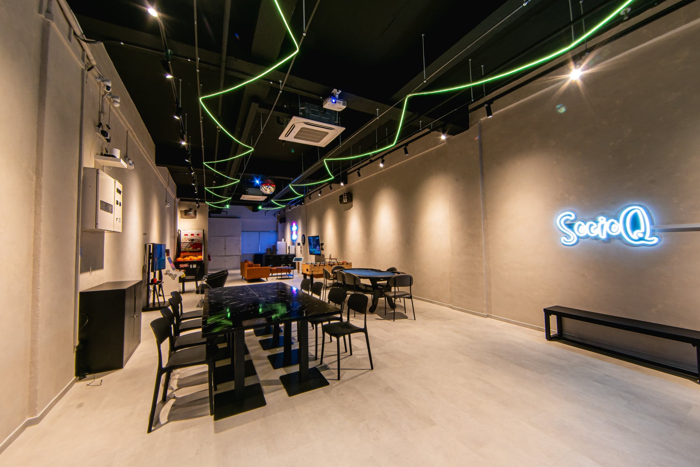 Lavender event space: long hall with neon ceiling lights and the SocioQ sign